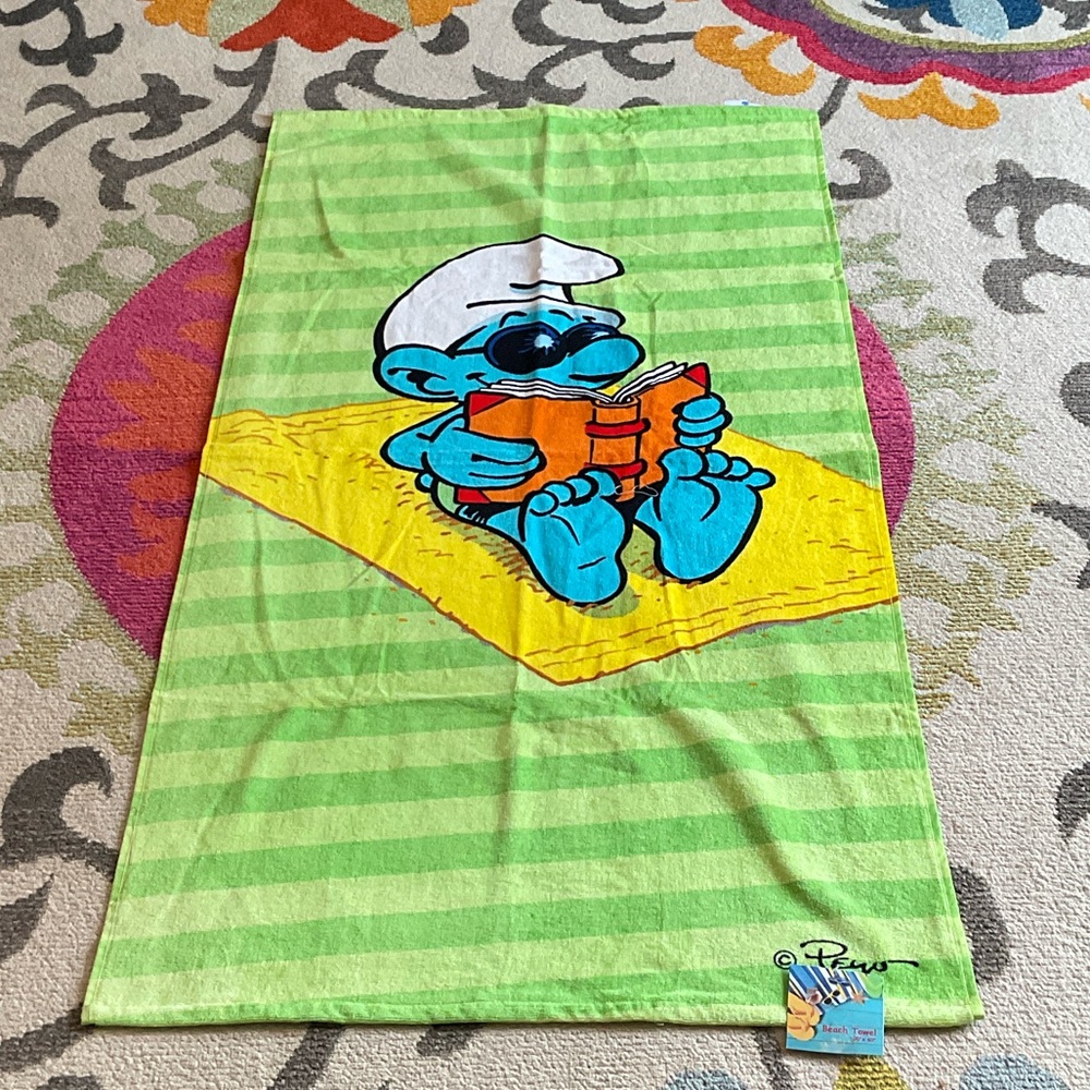 The Smurfs Green Striped Beach Towel Smurf reading a book on the beach
